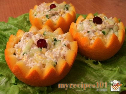 Salad with chicken filet and cucumbers in oranges